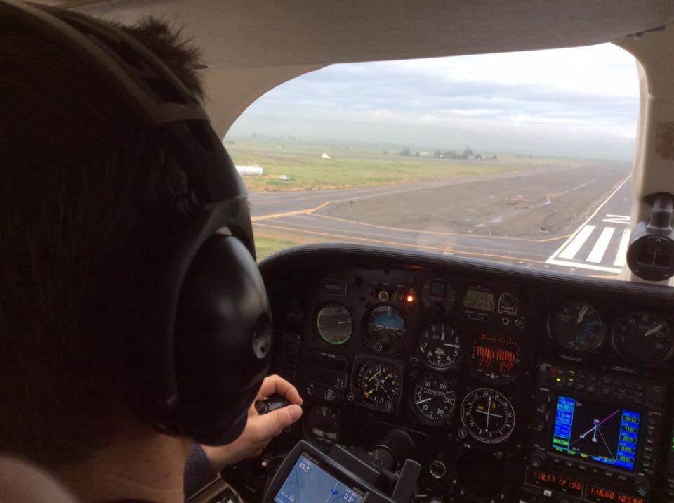 A man flying an airplane with headphones on.