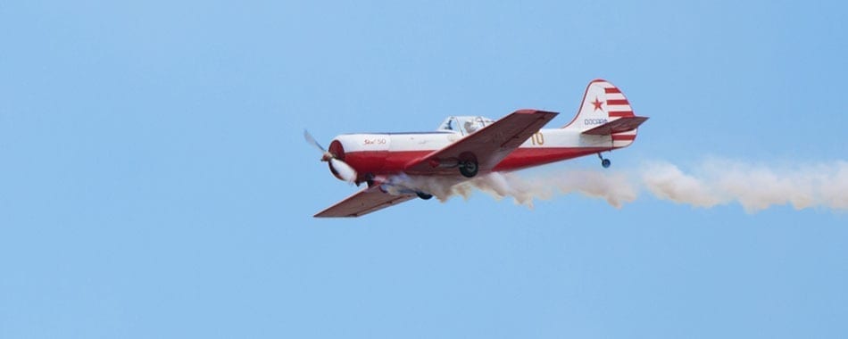 A red and white plane flying in the sky.